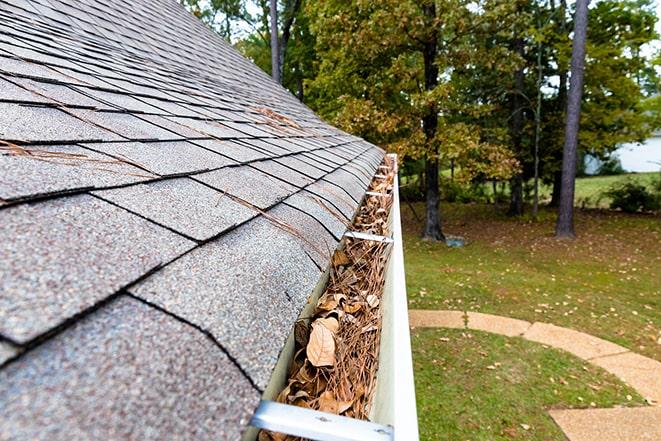 clearing out debris from rain gutter